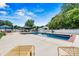 A pristine in-ground pool is surrounded by a spacious concrete patio, lounge chairs, and manicured landscaping at 312 Rumple St, Troutman, NC 28166