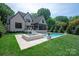 Expansive backyard featuring a pool, hot tub, stone patio, and lush lawn for entertaining at 3524 Lacie Ln, Charlotte, NC 28211