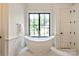 Spa-like bathroom featuring freestanding tub, large windows, marble accents, and modern fixtures at 3524 Lacie Ln, Charlotte, NC 28211