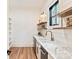 Bright butler's pantry features a marble countertop, sink, wood shelving, and black trim window at 3524 Lacie Ln, Charlotte, NC 28211