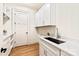 Well-lit laundry room with white cabinets, a countertop, and a sink at 3524 Lacie Ln, Charlotte, NC 28211