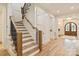 Elegant staircase with wood treads, iron railings, and an adjacent entryway at 3524 Lacie Ln, Charlotte, NC 28211