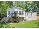 Back exterior view of the home with wooden deck and stairs overlooking the yard at 3529 Trent St, Charlotte, NC 28209
