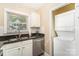 Well-organized kitchenette with stainless steel appliances and stacked washer and dryer at 3529 Trent St, Charlotte, NC 28209