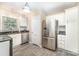 Well-lit kitchen featuring stainless steel appliances, white cabinetry, and stone countertops at 3529 Trent St, Charlotte, NC 28209