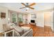 Bright living room featuring hardwood floors, a ceiling fan, comfortable seating, and multiple windows at 3529 Trent St, Charlotte, NC 28209