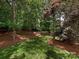 Lush green backyard with mature trees and landscaping creating a serene outdoor space at 3721 Providence Plantation Ln, Charlotte, NC 28270