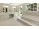 Elegant bathroom with marble countertop, dual sinks, soaking tub, and a window overlooking the lush lawn at 3721 Providence Plantation Ln, Charlotte, NC 28270