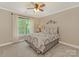 Bedroom with ceiling fan, carpeted floors, and large window at 3721 Providence Plantation Ln, Charlotte, NC 28270