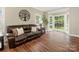 Comfortable living room with a brown leather sofa, decorative tree wall art, and a bay window at 3721 Providence Plantation Ln, Charlotte, NC 28270