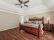 Comfortable main bedroom with tray ceiling, ceiling fan, and hardwood floors at 3721 Providence Plantation Ln, Charlotte, NC 28270