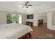 Comfortable main bedroom with tray ceiling, ceiling fan, hardwood floors, and view of the upstairs hallway at 3721 Providence Plantation Ln, Charlotte, NC 28270