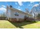 Back exterior view of the home featuring light gray siding, brick foundation, and wooden decks at 400 Joe Cloninger Rd, Bessemer City, NC 28016