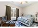 Bedroom features a ceiling fan, bright window, blue patterned rug, and a rocking chair at 400 Joe Cloninger Rd, Bessemer City, NC 28016