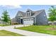 Side view of a charming home featuring a manicured lawn and a two-car garage at 4069 Havenport Cir, Fort Mill, SC 29708