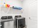 A modern laundry room features front-loading Samsung washer and dryer and a wire storage shelf at 4069 Havenport Cir, Fort Mill, SC 29708