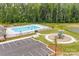 Aerial shot of a community pool and playground with ample parking and a scenic wooded backdrop at 4069 Havenport Cir, Tega Cay, SC 29708