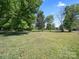 Vast backyard surrounded by mature trees, providing privacy and natural shade at 4101 New Castle Ln, Monroe, NC 28110