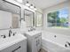 Updated bathroom with double vanity, white painted trim, and a large window for natural light at 4101 New Castle Ln, Monroe, NC 28110