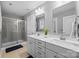 Modern bathroom featuring double sinks, white cabinets, and glass shower stall at 414 King St, Waxhaw, NC 28173