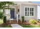 Inviting front entrance with a modern door, wooden steps, and manicured landscaping at 414 King St, Waxhaw, NC 28173