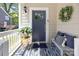 Welcoming front porch with stylish seating, an outdoor rug, and decorative plant at 414 King St, Waxhaw, NC 28173