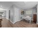 Hallway featuring wood flooring, neutral paint, and access to rooms, including a home office at 414 King St, Waxhaw, NC 28173