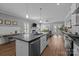 Bright open-concept kitchen featuring large island, stainless appliances, and connection to living room at 414 King St, Waxhaw, NC 28173