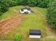 Aerial view of house with shed on large lot, featuring a lawn and wooded perimeter at 456 Rainbow Cir, Clover, SC 29710