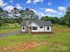 Charming white cottage-style home with stone chimney, black trim, and lush green lawn at 456 Rainbow Cir, Clover, SC 29710