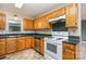 Functional kitchen featuring oak cabinets, tile floors, a refrigerator, and standard appliances at 4751 Kemp Dellinger Rd, Maiden, NC 28650