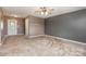 Spacious living room featuring neutral walls, carpet, a ceiling fan, and an exterior door at 4751 Kemp Dellinger Rd, Maiden, NC 28650