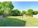 Expansive backyard featuring a lush lawn, wooden fence, and a greenhouse, perfect for gardening and outdoor activities at 4838 Holbrook Dr, Charlotte, NC 28212
