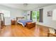 Bright bedroom featuring hardwood floors, a cozy bed, and natural light from the window at 4838 Holbrook Dr, Charlotte, NC 28212