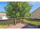 View of the wooden back deck, overlooking the backyard with mature tree and blue sky above at 5018 Drake Pond Ln, Rock Hill, SC 29732