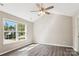 Bright bedroom featuring a large window, ceiling fan, and hardwood flooring at 5018 Drake Pond Ln, Rock Hill, SC 29732