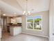 Open-concept dining area featuring tiled floors, modern lighting, and a view into the kitchen and backyard at 5018 Drake Pond Ln, Rock Hill, SC 29732