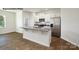 Bright open-concept kitchen boasts stainless appliances, white cabinets, and granite island at 547 Trading Post Ln, York, SC 29745