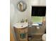 Cozy bathroom features a sink with vanity, round mirror, and a window providing natural light at 642 Boger St, Mooresville, NC 28115