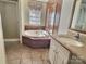 Bright bathroom featuring a soaking tub, tile floors, vanity with cabinets, and abundant natural light at 668 Osteen Rd, York, SC 29745