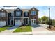 Charming townhome featuring stone accents, a two-car garage, and a well-manicured front lawn and long driveway at 733 Wagon Cross Ct, York, SC 29745