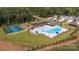 Aerial view of a community pool, playground, and tennis courts surrounded by lush greenery at 739 Wagon Cross Ct, York, SC 29745