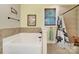 Bright bathroom featuring a soaking tub, tile surround, and a window for natural light at 7710 Grove Hall Ave, Mint Hill, NC 28227