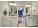 Bathroom featuring dual vanities, neutral tile, and view to a bonus room at 7710 Grove Hall Ave, Mint Hill, NC 28227