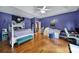 Bedroom showcasing vibrant blue walls, hardwood floors, and modern decor at 7710 Grove Hall Ave, Mint Hill, NC 28227