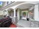 Inviting covered front porch with stone columns and arched entry offers curb appeal and outdoor space at 7710 Grove Hall Ave, Mint Hill, NC 28227