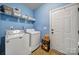 Well-organized laundry room features a washer, dryer, shelving, and convenient outdoor access at 7710 Grove Hall Ave, Mint Hill, NC 28227