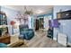 A cozy, eclectic living room featuring blue walls, hardwood flooring, and access to a kitchen at 7710 Grove Hall Ave, Mint Hill, NC 28227