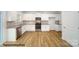 Modern kitchen featuring white cabinetry, stainless steel appliances, and wood-look flooring at 917 Two Brothers Ln, York, SC 29745