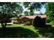 Charming brick home featuring a well-manicured lawn, red roof, and lush greenery at , Hickory, NC 28602